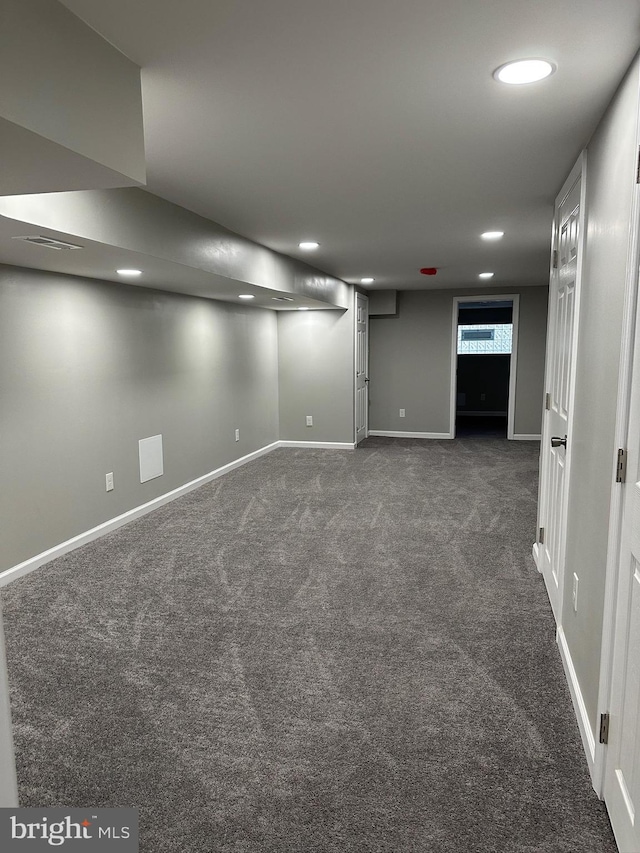 basement featuring dark carpet