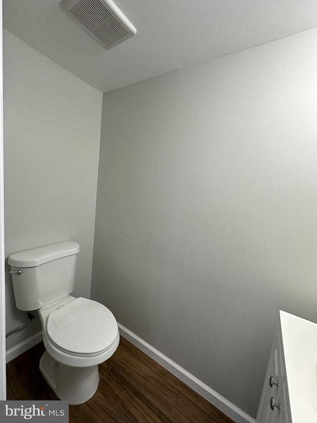 bathroom with vanity, hardwood / wood-style floors, and toilet