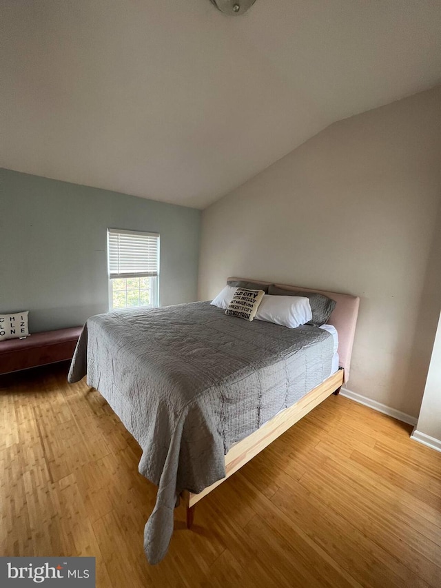 unfurnished bedroom featuring light hardwood / wood-style flooring and lofted ceiling