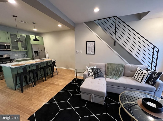 living room featuring sink and light hardwood / wood-style flooring