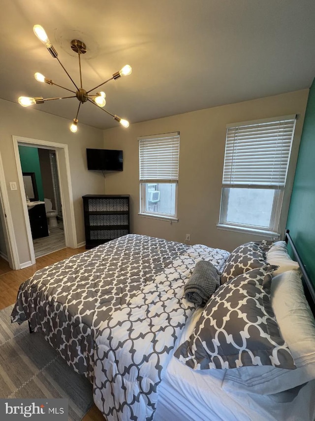 bedroom with cooling unit, wood-type flooring, multiple windows, and a chandelier