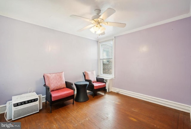 sitting room with a wall unit AC, ceiling fan, hardwood / wood-style flooring, and crown molding