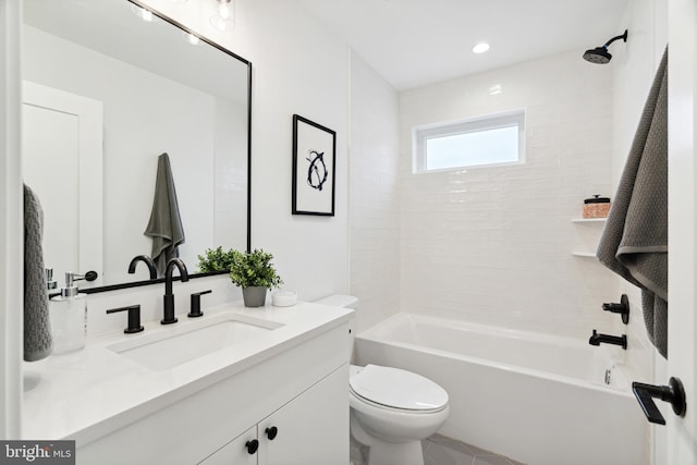 full bathroom featuring tiled shower / bath combo, vanity, and toilet