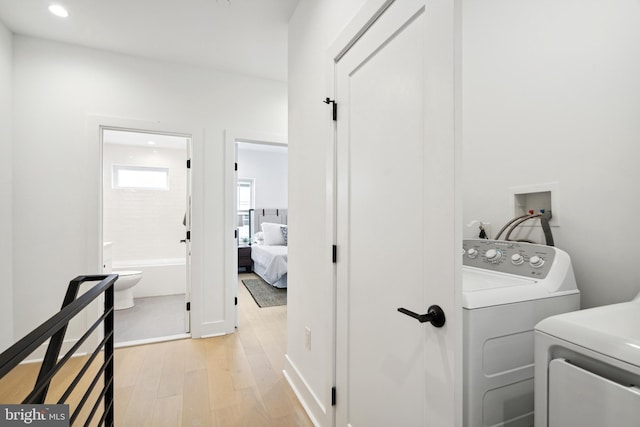 laundry area featuring light wood-type flooring and washing machine and clothes dryer