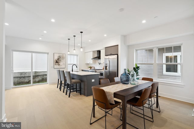 dining area with light hardwood / wood-style flooring and sink