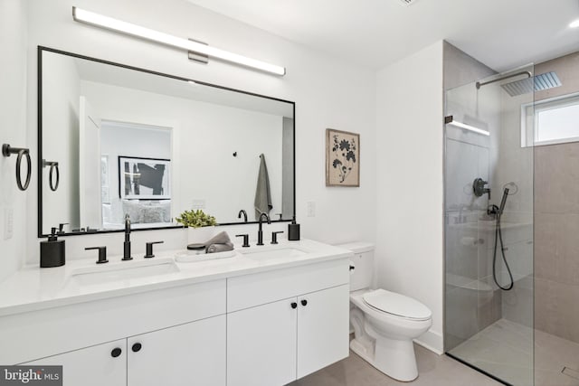 bathroom with a tile shower, tile patterned floors, vanity, and toilet