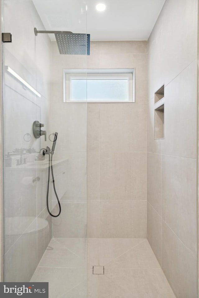 bathroom with a shower with door