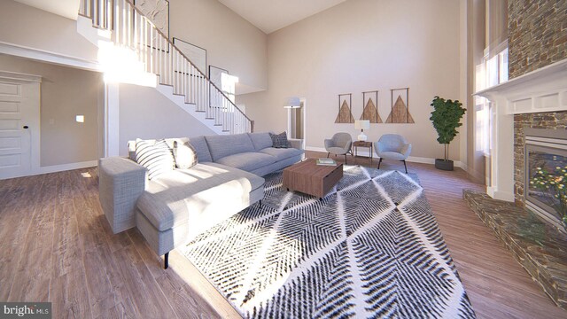 living room with a fireplace, a high ceiling, and hardwood / wood-style floors