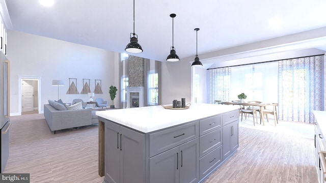 kitchen featuring gray cabinets, plenty of natural light, decorative light fixtures, and light hardwood / wood-style flooring