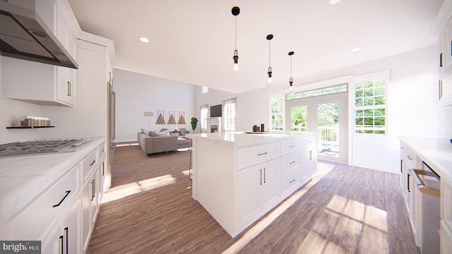 kitchen featuring wall chimney exhaust hood, pendant lighting, hardwood / wood-style floors, a center island, and white cabinetry