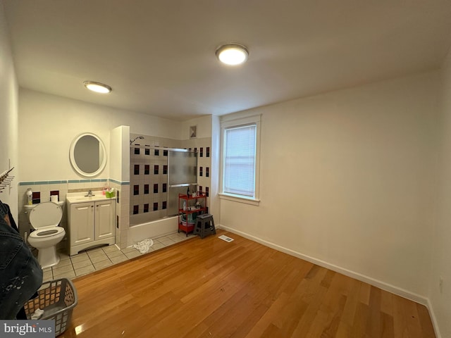 bathroom featuring vanity, toilet, an enclosed shower, and hardwood / wood-style floors