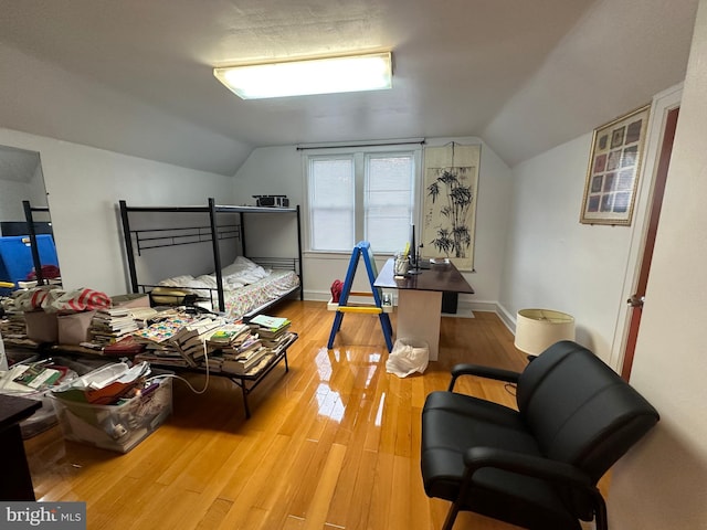 bedroom with hardwood / wood-style flooring and lofted ceiling