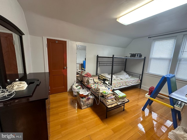 bedroom with light hardwood / wood-style floors and lofted ceiling