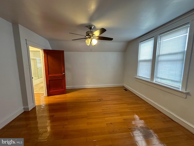 unfurnished room with lofted ceiling, light hardwood / wood-style floors, and ceiling fan