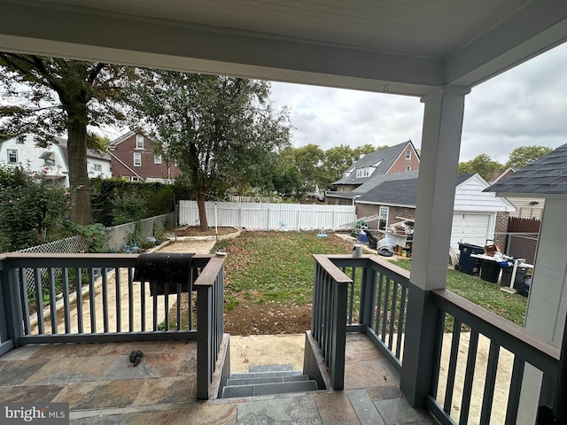 wooden deck with covered porch, an outdoor structure, a yard, and a garage