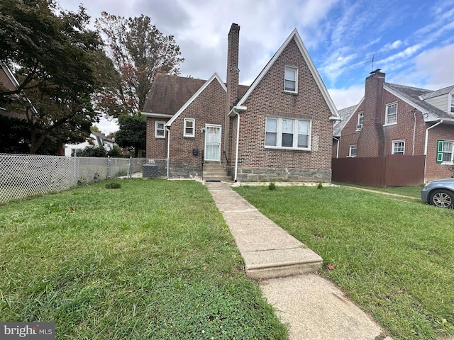 view of front of home featuring a front yard and central AC unit