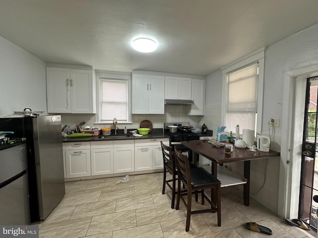 kitchen featuring sink, white cabinetry, stainless steel appliances, and plenty of natural light