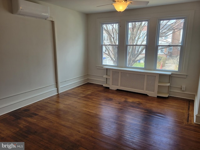 empty room featuring an AC wall unit, radiator, dark hardwood / wood-style floors, and a healthy amount of sunlight