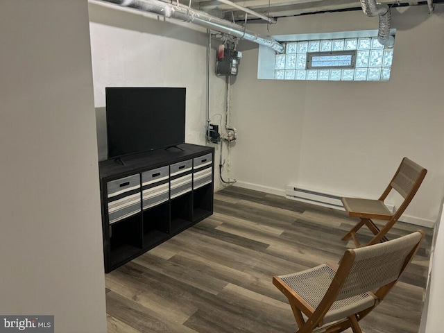 living area featuring dark hardwood / wood-style flooring and a baseboard heating unit