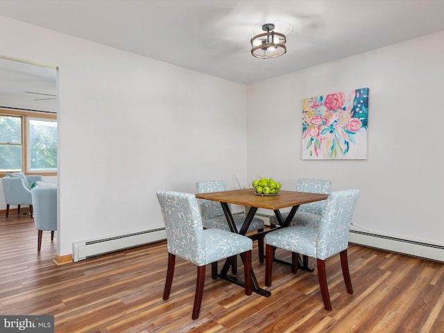 dining area with wood-type flooring and baseboard heating