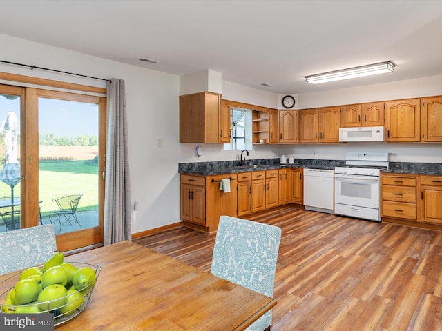 kitchen with hardwood / wood-style flooring, sink, and white appliances