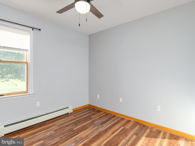 unfurnished room with dark wood-type flooring, ceiling fan, baseboard heating, and a healthy amount of sunlight