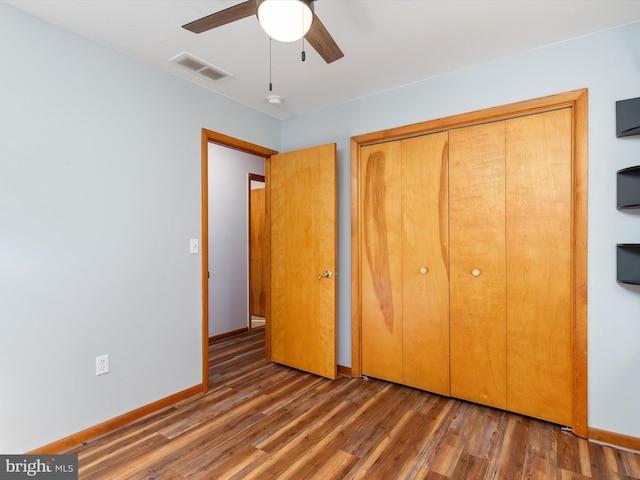 unfurnished bedroom with dark wood-type flooring, a closet, and ceiling fan