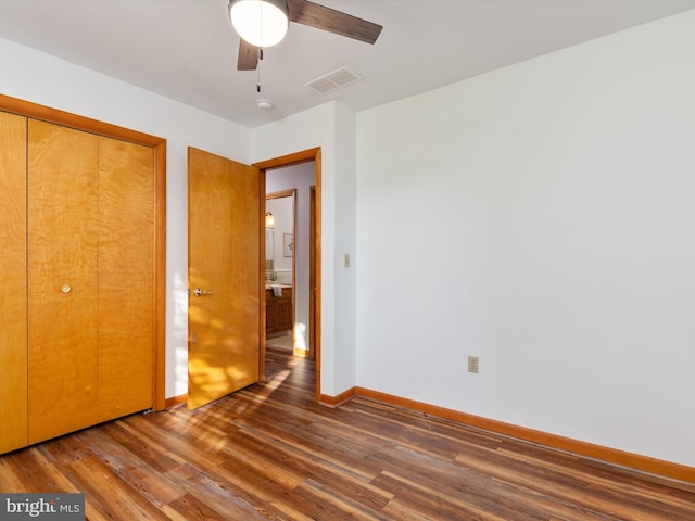 unfurnished bedroom with ceiling fan, a closet, and dark hardwood / wood-style floors