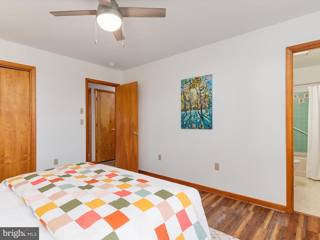 unfurnished bedroom featuring ceiling fan, ensuite bath, and dark wood-type flooring