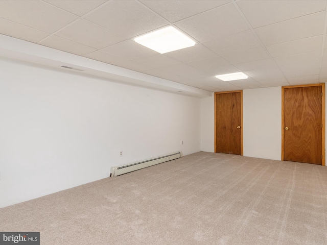 basement with carpet floors, a drop ceiling, and baseboard heating