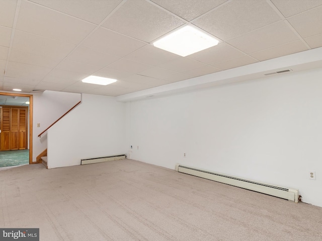 basement with a drop ceiling, carpet flooring, and a baseboard radiator