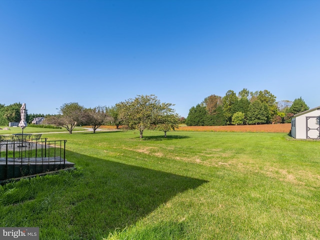 view of yard featuring a rural view and a shed