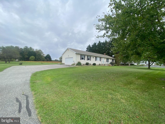 ranch-style home featuring a garage and a front lawn