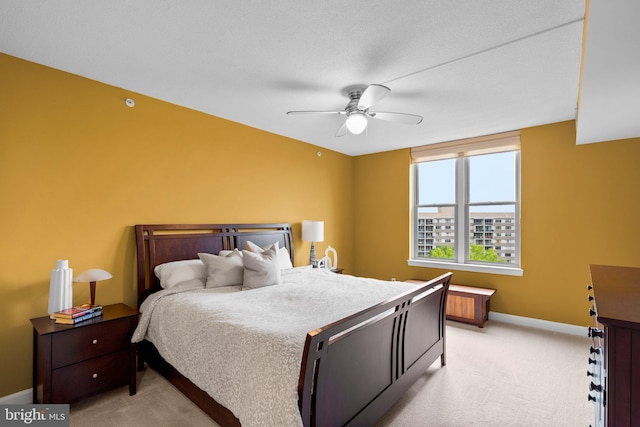 carpeted bedroom with ceiling fan and a textured ceiling