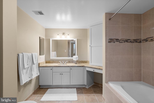 bathroom featuring vanity, tile patterned floors, and tiled shower / bath