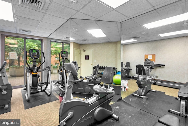 workout area with carpet floors and a drop ceiling