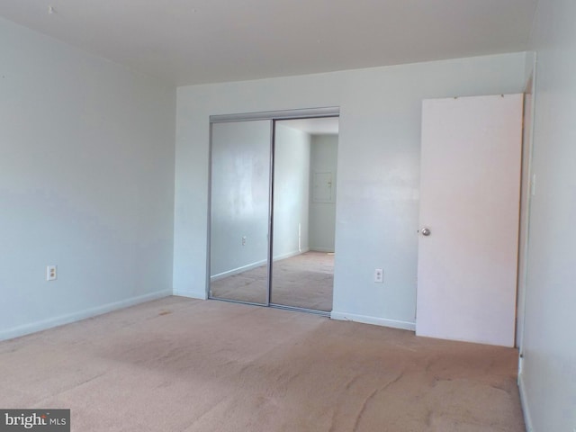 unfurnished bedroom with a closet, baseboards, and carpet flooring
