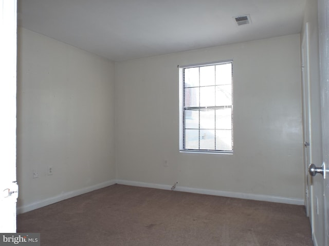 unfurnished room with visible vents, baseboards, and carpet