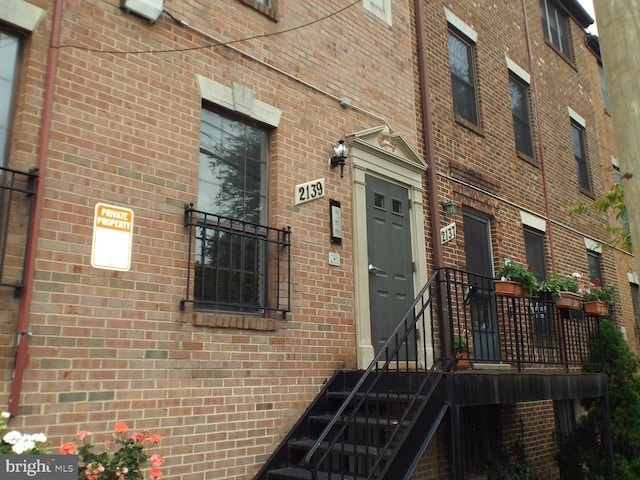 doorway to property featuring brick siding