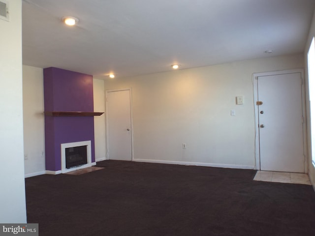 unfurnished living room with carpet flooring, a fireplace, and baseboards