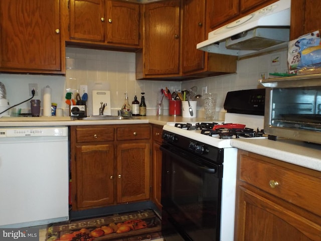 kitchen featuring white appliances, tasteful backsplash, and sink