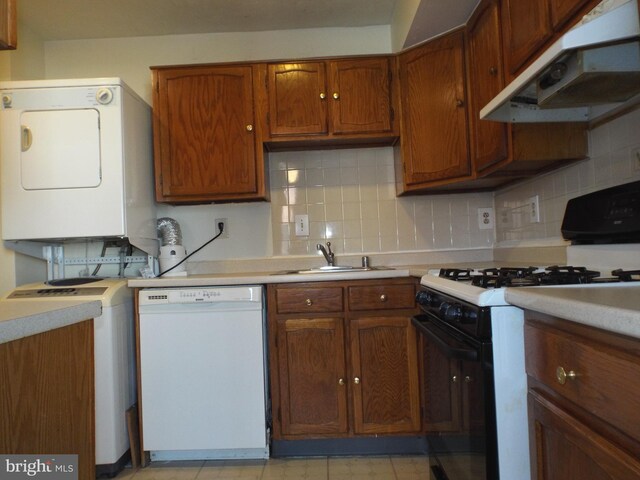 kitchen with range with gas stovetop, light countertops, under cabinet range hood, white dishwasher, and a sink