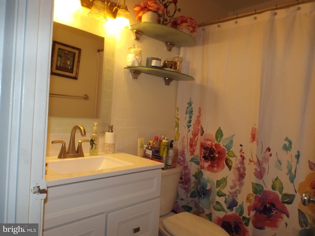 bathroom featuring a shower with shower curtain, backsplash, vanity, and toilet