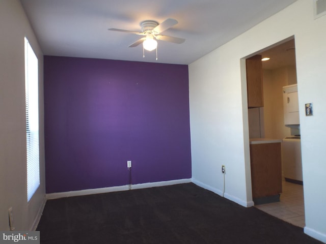 tiled spare room with visible vents, baseboards, and a ceiling fan