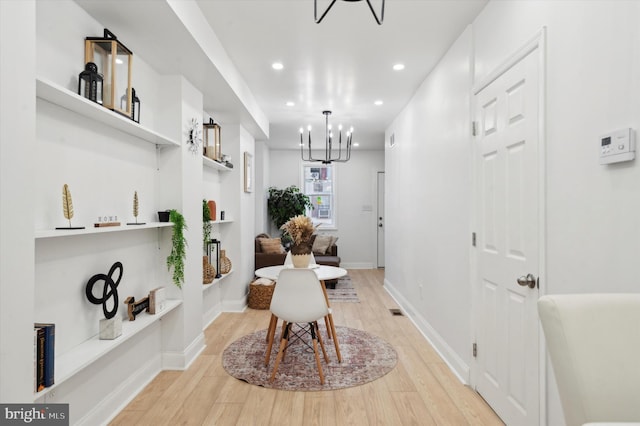 interior space with light hardwood / wood-style floors and a chandelier