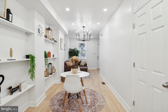 interior space with light hardwood / wood-style floors and a chandelier