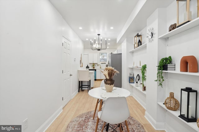 dining room featuring a notable chandelier and light hardwood / wood-style flooring