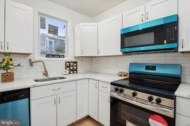 kitchen featuring decorative backsplash, sink, white cabinets, and appliances with stainless steel finishes