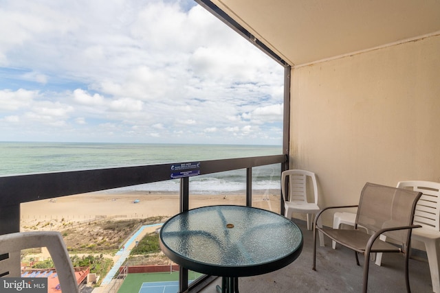 balcony with a beach view and a water view