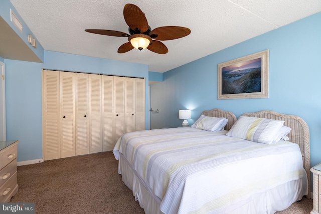 carpeted bedroom with a closet, ceiling fan, and a textured ceiling